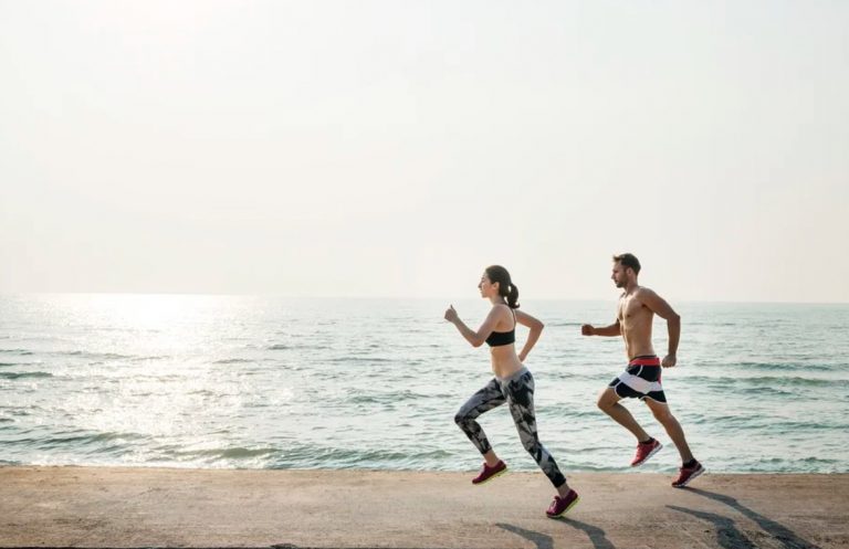 Man and woman running on the coastline